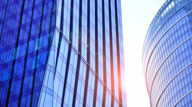 Çelik ve camdan yapılmış modern ofis binası. Ofis binasının pencereleri. Güneş ışığıyla soyut mimari kavram.