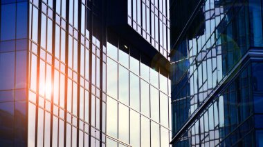 Çelik ve camdan yapılmış modern ofis binası. Ofis binasının pencereleri. Güneş ışığıyla soyut mimari kavram.