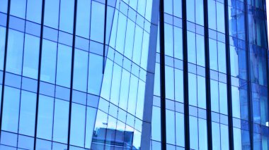 Çelik ve camdan yapılmış modern bir bina, konut ofisleri ve finans kurumları. Binanın ön cephesinde cam duvar var..