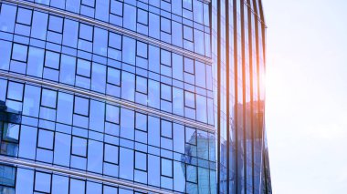 Çelik ve camdan yapılmış modern ofis binası. Ofis binasının pencereleri. Güneş ışığıyla soyut mimari kavram.