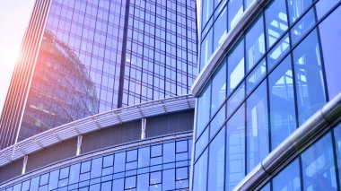 Çelik ve camdan yapılmış modern ofis binası. Ofis binasının pencereleri. Güneş ışığıyla soyut mimari kavram.