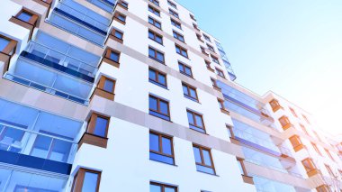 Kentsel yaşam ve modern mimari kavramı. Camdan balkonları ve beyaz cepheli modern apartman manzarası. Avrupa 'da çağdaş apartman binası.