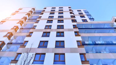 Kentsel yaşam ve modern mimari kavramı. Camdan balkonları ve beyaz cepheli modern apartman manzarası. Avrupa 'da çağdaş apartman binası.