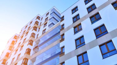 Kentsel yaşam ve modern mimari kavramı. Camdan balkonları ve beyaz cepheli modern apartman manzarası. Avrupa 'da çağdaş apartman binası.
