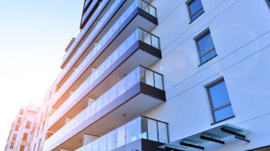 Kentsel yaşam ve modern mimari kavramı. Camdan balkonları ve beyaz cepheli modern apartman manzarası. Avrupa 'da çağdaş apartman binası.