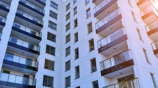 Kentsel yaşam ve modern mimari kavramı. Camdan balkonları ve beyaz cepheli modern apartman manzarası. Avrupa 'da çağdaş apartman binası.