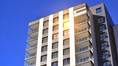 Çok katlı, modern bir apartmanın dış cephesi, pencereleri ve balkonları..