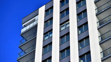 Çok katlı, modern bir apartmanın dış cephesi, pencereleri ve balkonları..