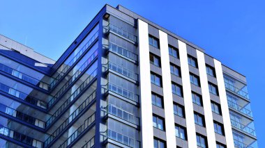 Çok katlı, modern bir apartmanın dış cephesi, pencereleri ve balkonları..