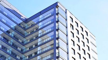 Çok katlı, modern bir apartmanın dış cephesi, pencereleri ve balkonları..