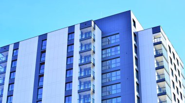 Çok katlı, modern bir apartmanın dış cephesi, pencereleri ve balkonları..