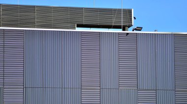 Fütürist bina dikey kaplama çelik çerçeve panelleri tasarladı. Alüminyum metal kompozit panelleri olan çağdaş ticari bir binanın dış duvarı..