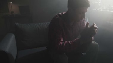 Ayrıldıktan sonra karanlık odada yalnız oturan kalbi kırık bir adam.