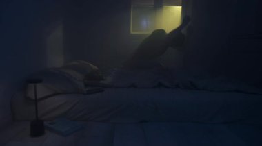 Öfkeli adam umutsuzluk içinde yatağa düşüyor, duygusal çöküntü ve karanlık yatak odasında umutsuzluk. Başarısızlık, öfke ve depresyon kavramı.