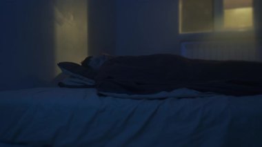 Genç adam geceleri karanlık bir yatak odasında uyuyamıyor. Huzursuzluk ve uykusuzluk havası, yakın çekim yaşam tarzı.