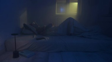 Yatakta uyuyamayan bir adam, pencereden içeri giren sıcak sarı bir sokak lambası, uykusuzluk ve geceleri uykusuzluk çeken bir adam..