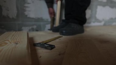Gerçek ev inşaatı sırasında tahta döşeme tahtasına çekiç ve uzay aracı kullanarak dokunmak. Doğal araç ve malzemeler ile otantik DIY inşa süreci.