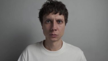 Kameraya bakarak kendinden emin bir şekilde başını sallıyor..