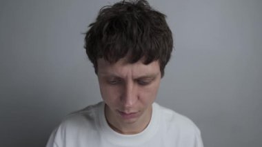 Zorla gülümseyerek endişelerini gizlemeye çalışan bir adam..