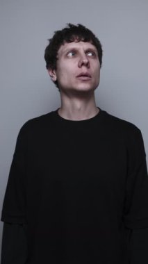 Adam uzaktan patlama ve hava saldırısı sesi duyuyor, endişeli bir portre korku içinde yukarı bakıyor..