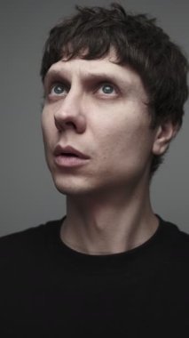 Adam uzaktan patlama ve hava saldırısı sesi duyuyor, endişeli bir portre korku içinde yukarı bakıyor..