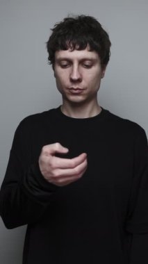 Telefon ve kaydırma kontrol adam nötr gri arka plan görevleri dikkat dağıtmak