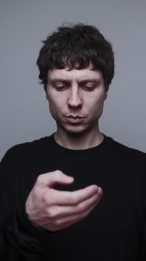 Telefondaki haberlerde kayan adam endişeli ve gri stüdyo geçmişi yüzünden bunalmış durumda.