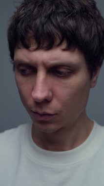 Sakin bir adam kafasını yavaşça çevirir ve düşünceli bir tarafsız ifadeyle bir şeyi gözlemler ve değerlendirir. Dikkatli analiz ve karar verme kavramı.