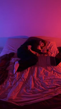 Yatakta telefona sarılan adam farklı anlarda kıvrılıp yatıyor. Dijital yorgunluk, online sohbet, modern rutin, Z kuşağı ve bin yıllık yaşam tarzını gösteren sahneleri değiştiriyor.