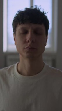 Evde sabah rutin meditasyonu, yatak odasındaki paspasın üzerinde farkındalık egzersizi yapan dövmeli bin yıllık adam, gündüz yaşam tarzı sahnesi, gerçek hayat.