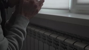 Soğuk bir apartman hayatı, battaniyeye sarılı bir adam radyatörün yanında sıcak çay içiyor, kış sıcağında evde donuyor..