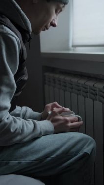 Soğuk bir apartman hayatı, battaniyeye sarılı bir adam radyatörün yanında sıcak çay içiyor, kış sıcağında evde donuyor..