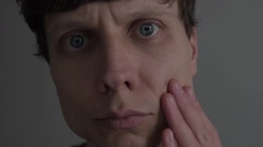 Yüzündeki tek sivilceyi fark eden adam aynadaki deriyi, sivilceleri ve lekeleri, gerçekçi cilt bakımını ve kişisel bakım kavramını inceliyor..