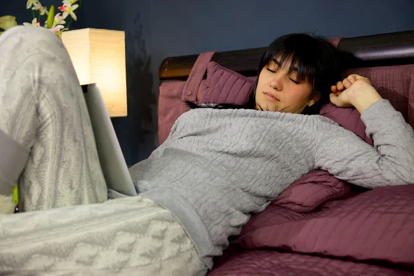 Jeune femme mignonne dormant avec tablette sur la jambe dans la chambre — Photo