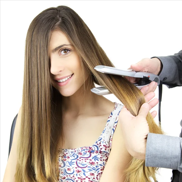 Niedliche glückliche Frau bekommt lange Haare von Friseur in Studio Nahaufnahme geglättet — Stockfoto