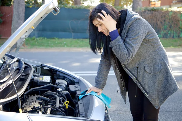 Žena zoufalé o rozbité auto hledat motor — Stock fotografie