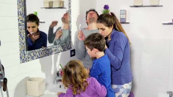 Madre padre y dos niños se divierten en el baño lavando dientes — Vídeos de Stock