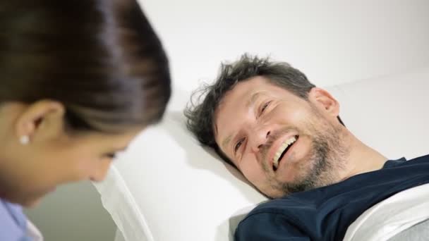 Счастливый пациент в больнице улыбается, разговаривая с доктором крупным планом — стоковое видео