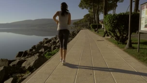 Mujer Feliz Corriendo Frente Lago Cámara Lenta Desde Atrás — Vídeos de Stock