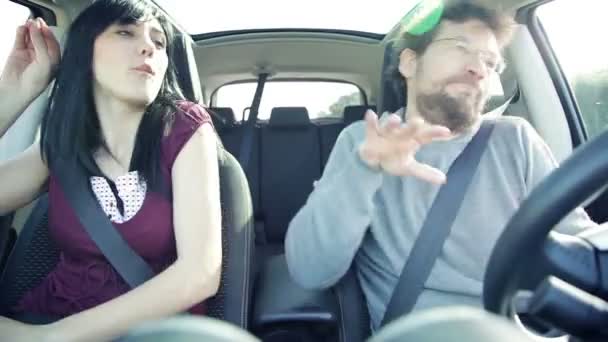 Счастливая веселая пара танцует в машине за рулем в отпуске — стоковое видео