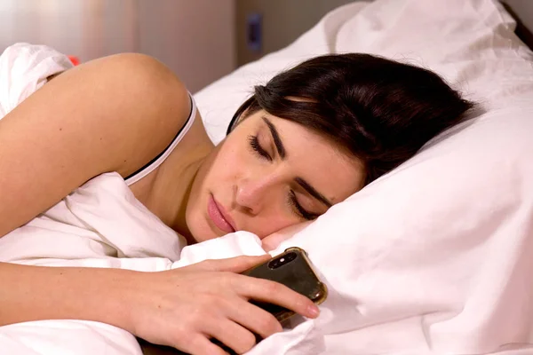 睡在床上的妇女手持手机成瘾概念 — 图库照片