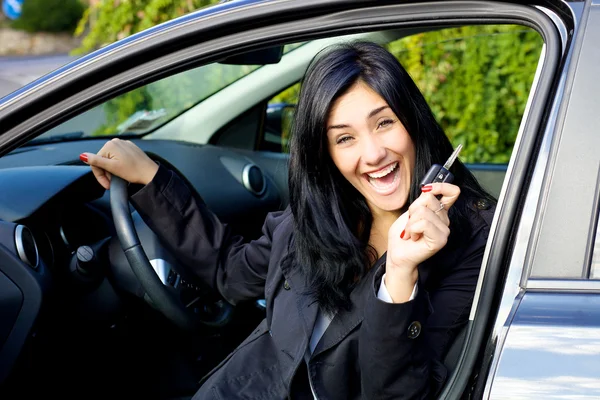 Giovane donna sorridente felice di auto nuova — Foto Stock