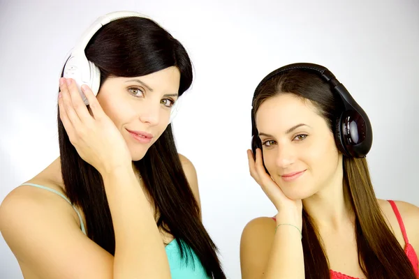 Twee jonge vrouwen luisteren muziek met headset — Stockfoto