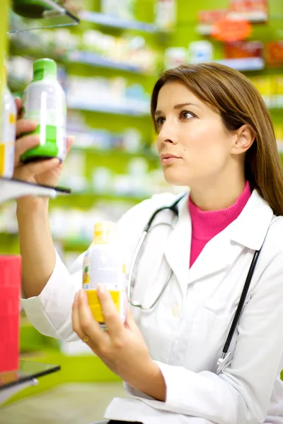 Vrouwelijke apotheker werken met geneeskunde in apotheek — Stockfoto