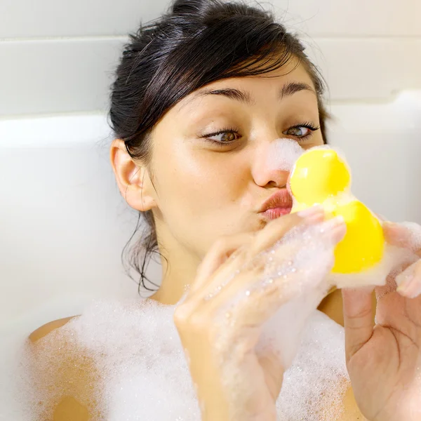 Donna che si diverte con anatra gialla nella vasca da bagno — Foto Stock