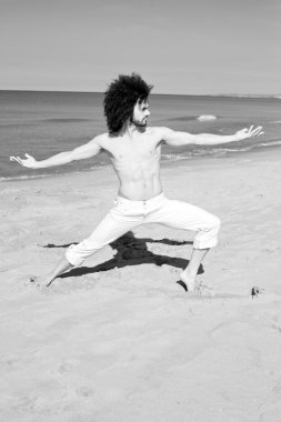 Kumsalda yoga yaparken ciddi yakışıklı adam