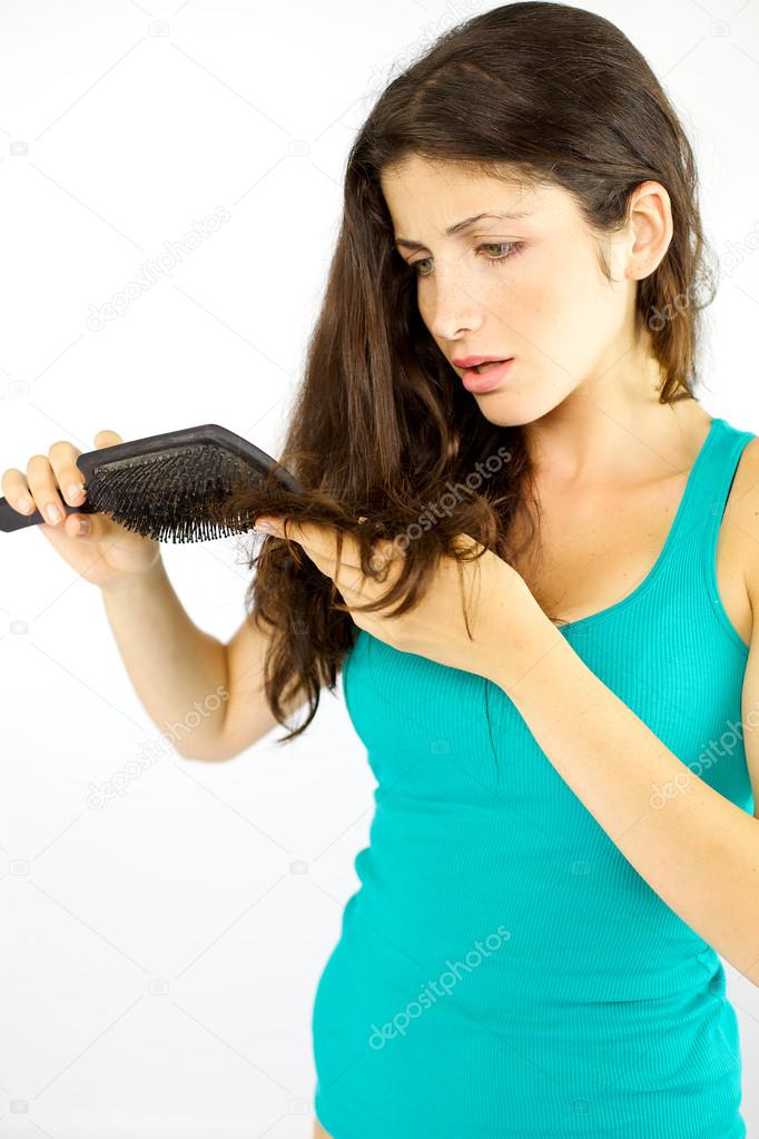 Woman seeing split ends in her long hair while brushing