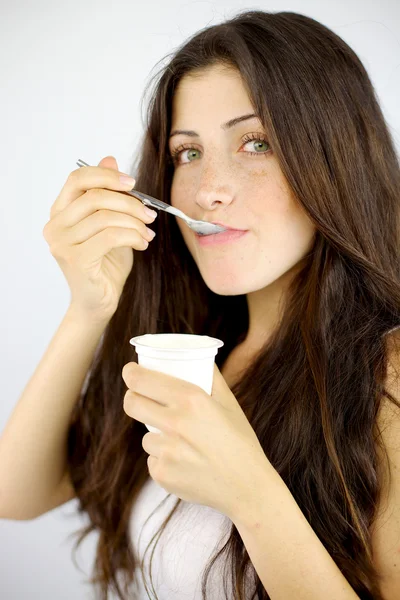 Brunetta ragazza mangiare bianco yogurt — Foto Stock