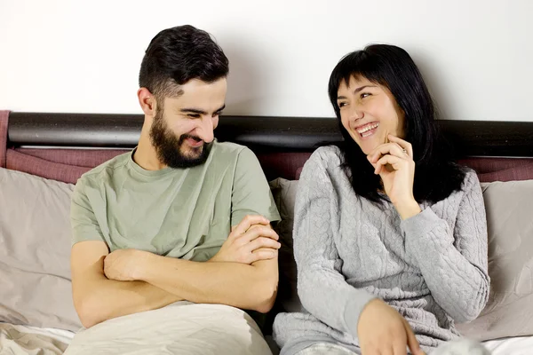 Gelukkige jonge paar glimlachend in bed gelukkig — Stockfoto