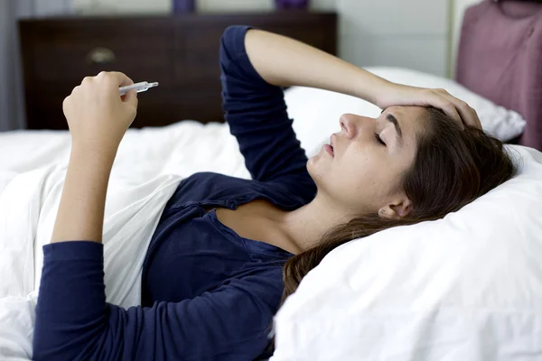 Vrouw in bed gevoel sterk hoofdpijn met griep — Stockfoto